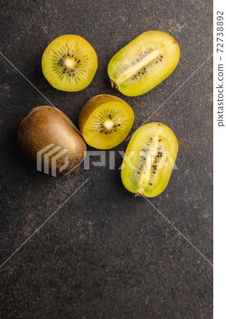 Halved ripe yellow kiwi fruit. 72738892