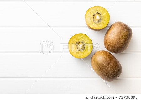 Halved ripe yellow kiwi fruit. 72738893