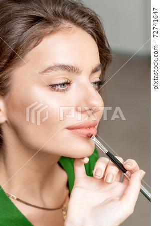 Makeup artist applies lipstick. Makeup artist applies lipstick. 72741647