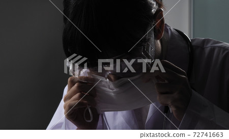 Doctor wearing protection face mask against coronavirus before work night ward in hospital. medical stuff preventive gear. Woman wearing an anti virus protective medical mask to prevent COVID-19 Doctor wearing protection face mask against coronavirus before work night ward in hospital. medical stuff preventive gear. Woman wearing an anti virus protective medical mask to prevent COVID-19 72741663