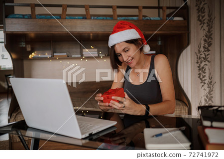 Christmas online congratulations. Smiling woman using pc computer for video call friends or parents. Christmas online congratulations. Smiling woman using pc computer for video call friends or parents. 72741972