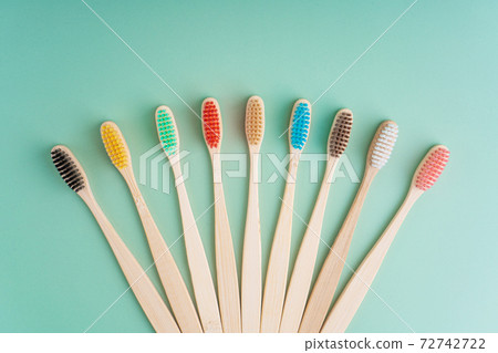 A set of Eco-friendly antibacterial toothbrushes made of bamboo wood on a light green background. Environmental care trends A set of Eco-friendly antibacterial toothbrushes made of bamboo wood on a light green background. Environmental care trends 72742722