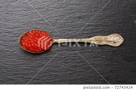 red caviar of chum salmon in a metal spoon on a black background 72743424