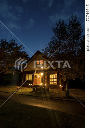 Evening bonfire and mountain lodge 72744645
