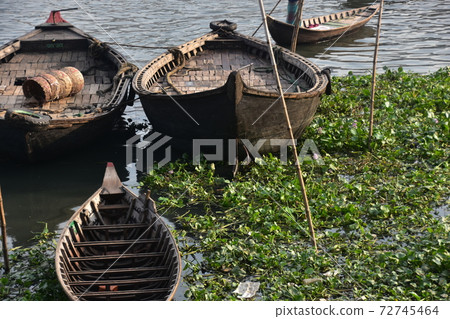Many ferryboats parked in Dhaka Shodolgat, Bangladesh, an old small boat made of wood 72745464