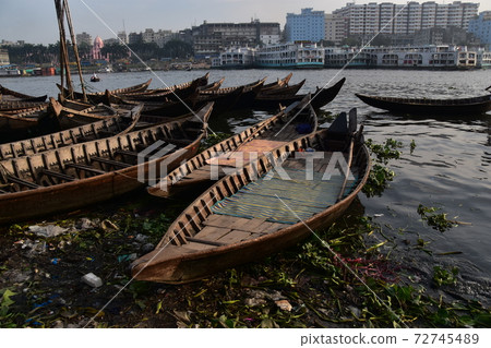 沿河建造的現代建築，停泊在孟加拉國達卡Shodolgat的許多渡輪和中型客船 72745489