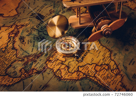 Old compass discovery and wooden plane on vintage paper antique world map Old compass discovery and wooden plane on vintage paper antique world map 72746060