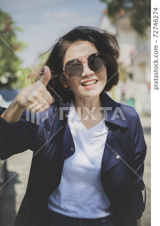 woman toothy smiling face show right thumb outdoor woman toothy smiling face show right thumb outdoor 72746274