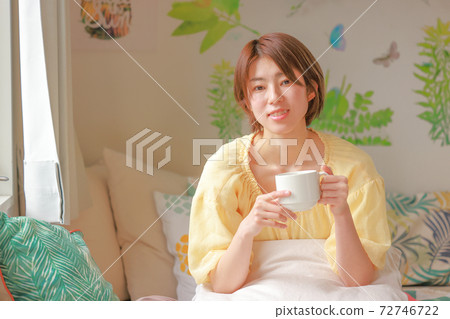 兩隻手中的拿著咖啡杯的微笑的婦女 72746722