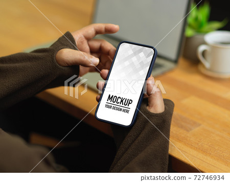 Cropped shot of male hands using smartphone while sitting at workplace 72746934