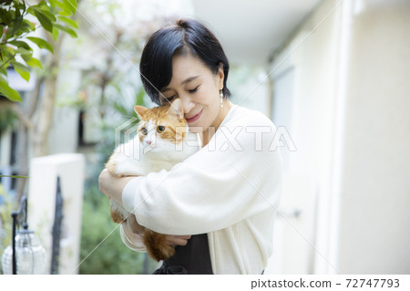 A woman holding a cat 72747793