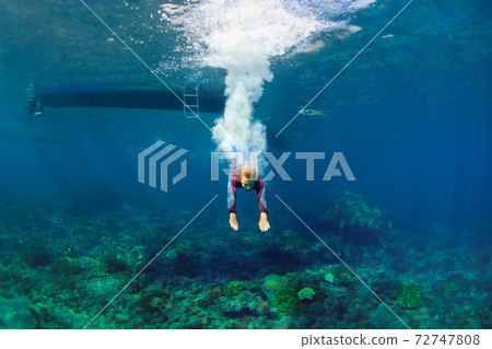Young woman diving underwater 72747808