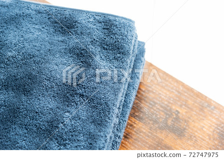 Blue face towel on the walnut table Blue face towel on the walnut table 72747975