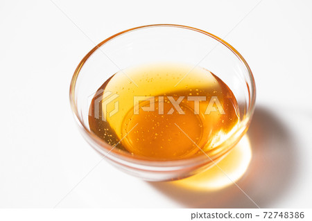 Honey syrup poured into a glass ball Honey syrup poured into a glass ball 72748386