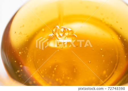 Honey syrup poured into a glass ball Honey syrup poured into a glass ball 72748398