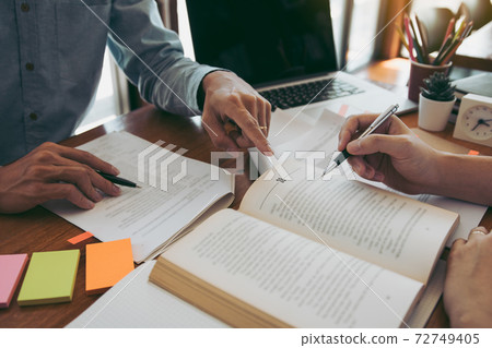 Teenager studying at desk and doing homeworks 72749405