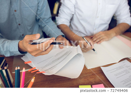 Asian young university students studying together sitting at desk in library. 72749406