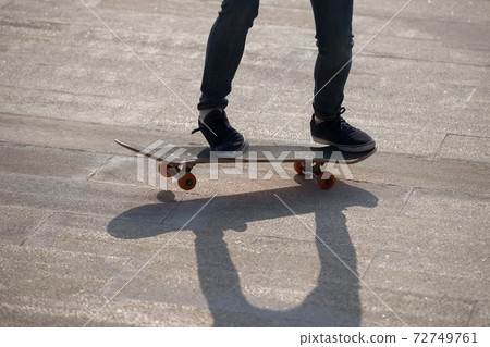 Asian woman skateboarder skateboarding in modern city Asian woman skateboarder skateboarding in modern city 72749761