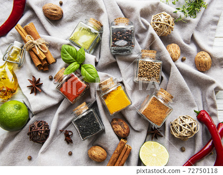 Jars with dried herbs, spices on the table Jars with dried herbs, spices on the table 72750118