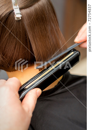 Hairdresser straightening the short hair 72754837