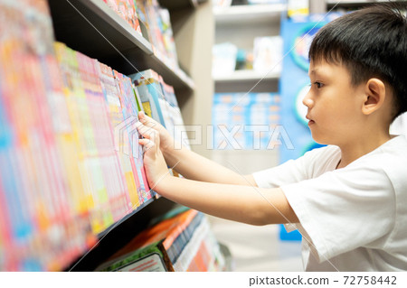 Asian little child selecting book while visiting bookshop,serious kid boy searching and looking for a fairy tale book in bookstore or choose a book from a bookshelf in a public library,reading concept Asian little child selecting book while visiting bookshop,serious kid boy searching and looking for a fairy tale book in bookstore or choose a book from a bookshelf in a public library,reading concept 72758442