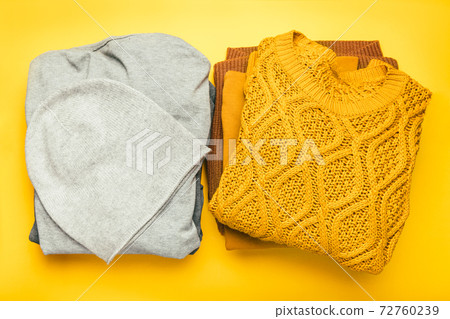 Stacks of gray and yellow clothing 72760239