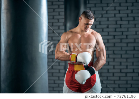 strong sportsman boxer exercising in white gloves at gym 72761196