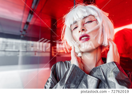 Fashion portrait of a blonde on a red background. 72762019
