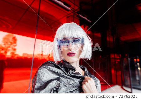 Fashion portrait of a blonde on a red background. Fashion portrait of a blonde on a red background. 72762023