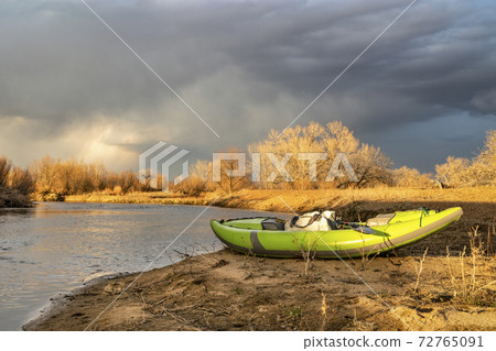 whitewater inflatable kayak on a river shore 72765091