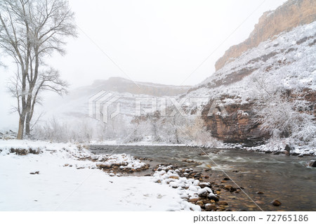 mountain river in a heavy April snowstorm mountain river in a heavy April snowstorm 72765186