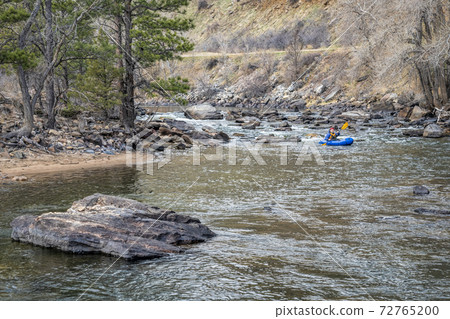 paddler in  packraft on mountain river 72765200