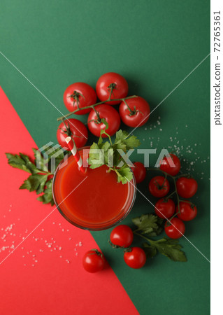 Glass of tomato juice and tomatoes on two tone background 72765361