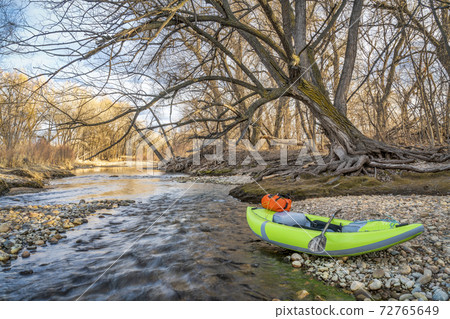 whitewater inflatable kayak on a river shore whitewater inflatable kayak on a river shore 72765649