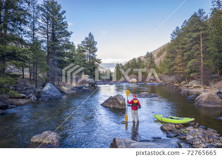 male paddler with an inflatable whitewater kayak 72765665