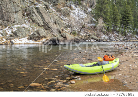 inflatable whitewater kayak on a rocky shore of a mountain river 72765692