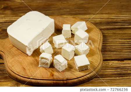 Feta cheese on cutting board on a wooden table Feta cheese on cutting board on a wooden table 72766236