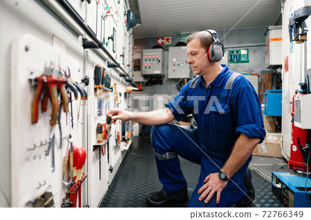 Marine engineer officer in engine control room ECR. He works in workshop 72766349