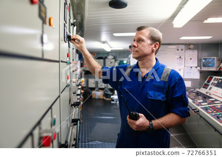 Marine engineer officer controlling vessel engines and propulsion in engine control room Marine engineer officer controlling vessel engines and propulsion in engine control room 72766351