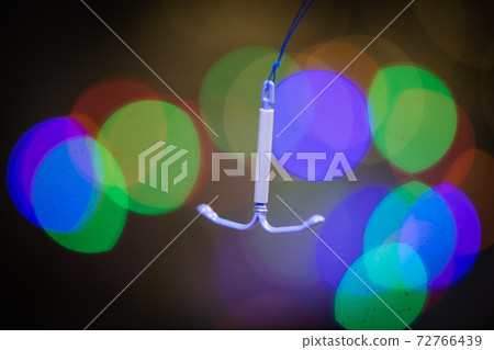 Holding an IUD birth control copper coil device, used for contraception Holding an IUD birth control copper coil device, used for contraception 72766439