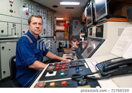 Marine engineer officer controlling vessel engines and propulsion in engine control room Marine engineer officer controlling vessel engines and propulsion in engine control room 72766589