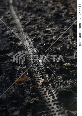 5 - Diagonal bike tyre track leads along a very muddy path in winter 72767711