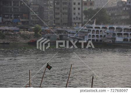 Dhaka, Bangladesh, large and small ships parked at Shodrugat, a residence and a building under construction along the river 72768097
