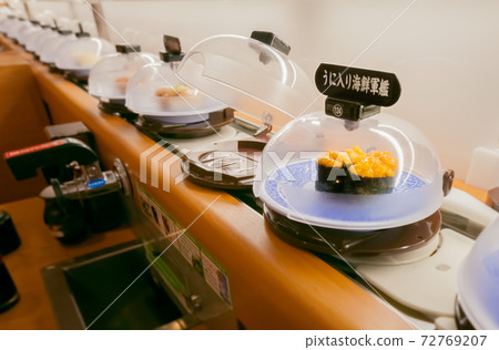Sea urchin gunkanmaki flowing over the conveyor belt sushi lane Sea urchin gunkanmaki flowing over the conveyor belt sushi lane 72769207