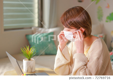 Telework_Woman試圖在她的耳朵上戴口罩 72769716