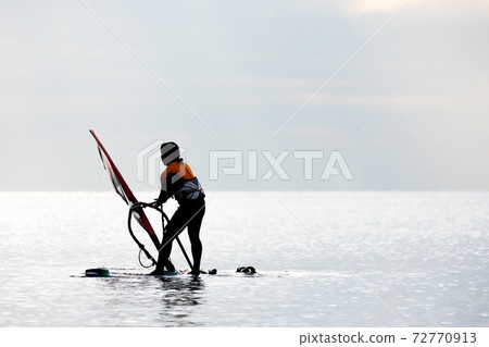 Windsurfing as if flying over the water while receiving the wind 72770913
