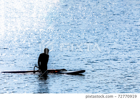 Windsurfing as if flying over the water while receiving the wind 72770919