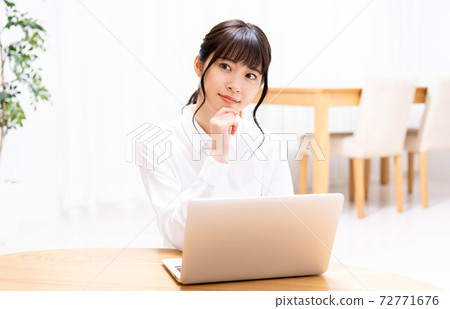 在客廳裡使用筆記本電腦的女士 在客廳裡使用筆記本電腦的女士 72771676