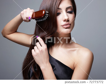 Beautiful girl combing her hair. fashion beauty portrait Beautiful girl combing her hair. fashion beauty portrait 72773772