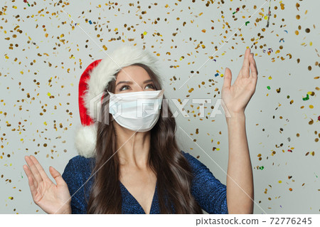 Pretty smiling woman in Santa hat  72776245
